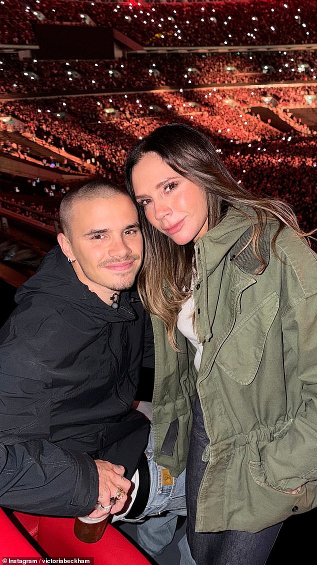 She posed happily with her son Romeo, 23, in their box