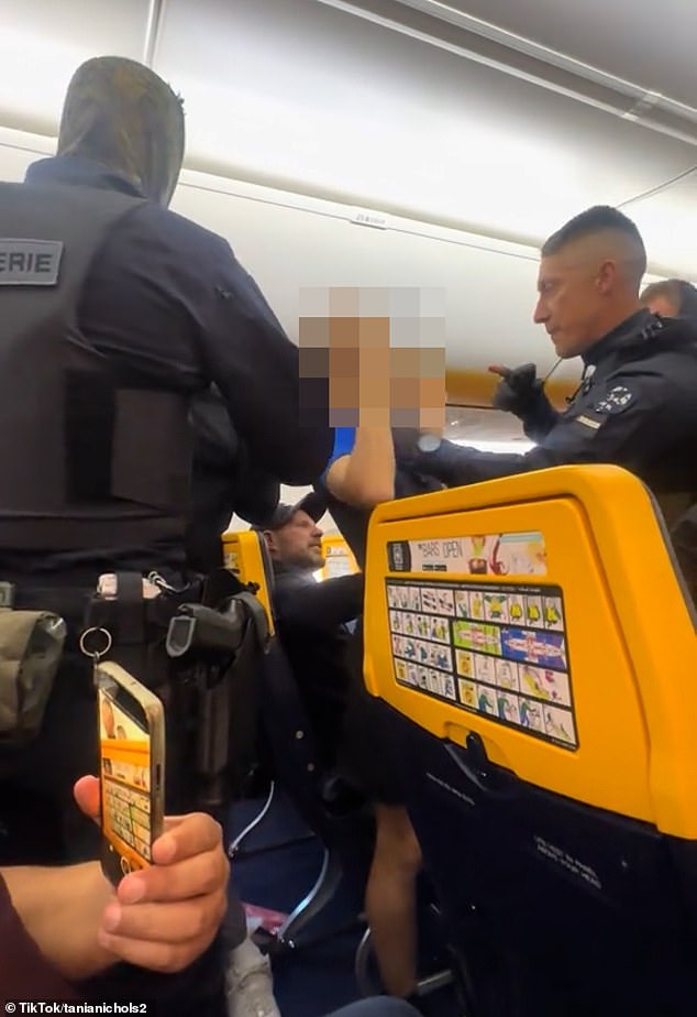 Shouting into the flyer's camera, the son directs her to stop filming, before warning an officer: 'You're making a mistake if you're coming for me'