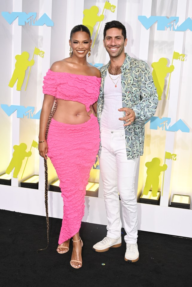 Kamie Crawford in a pink dress and Nev Schulman in a patterned shirt and white pants at the MTV Video Music Awards.