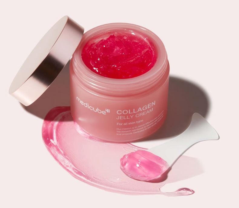 Medicube Collagen Jelly Cream in a pink jar with a gold lid, next to a white spatula with pink jelly cream.