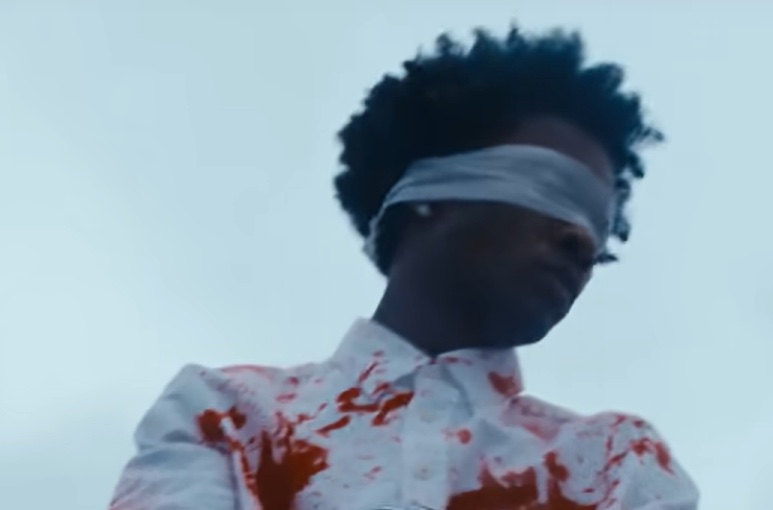 Singer-songwriter D4vd blindfolded and wearing a blood-stained shirt.