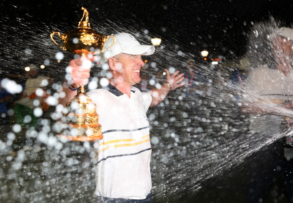 FARMINGDALE, NEW YORK - SEPTEMBER 28: Captain Luke Donald of Team Europe holds the Ryder Cup trophy as he is doused with champagne by Rory McIlroy (Not Pictured) after Team Europe defeated Team United States 15-13 during the Sunday singles matches of the 2025 Ryder Cup at Black Course at Bethpage State Park Golf Course on September 28, 2025 in Farmingdale, New York. (Photo by Richard Heathcote/Getty Images)