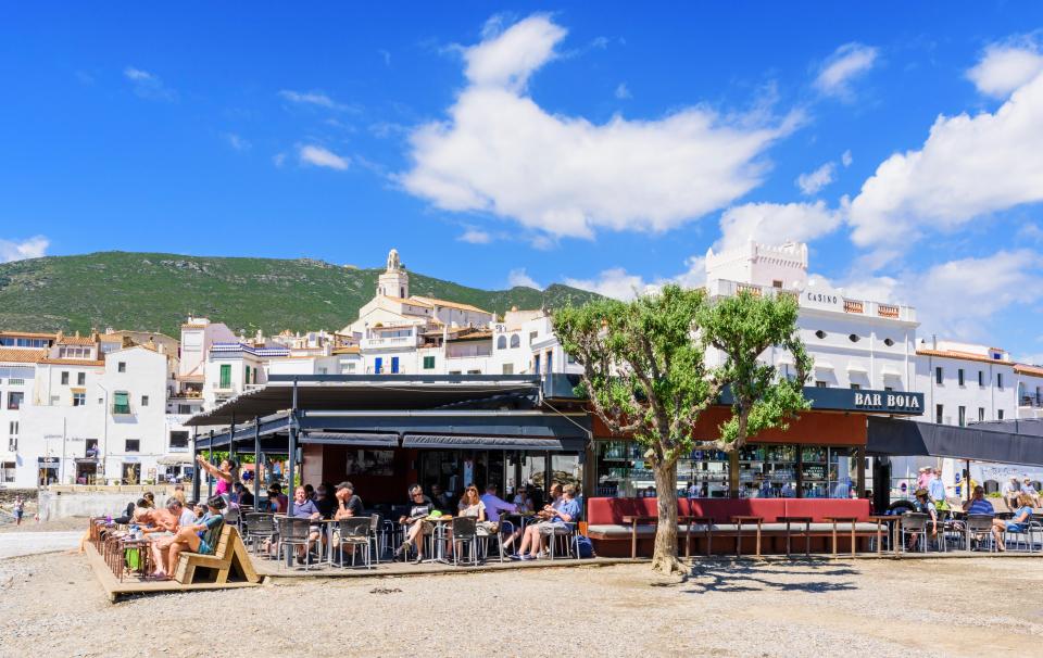 Busy beach bar on Cadaques Town main beach in Cadaques, Catalonia, Spain.