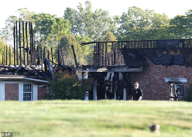 At least four people were killed and eight were left wounded on Sunday. Authorities said they would be searching the building ruins for more victims. (Pictured: The charred church on Monday)