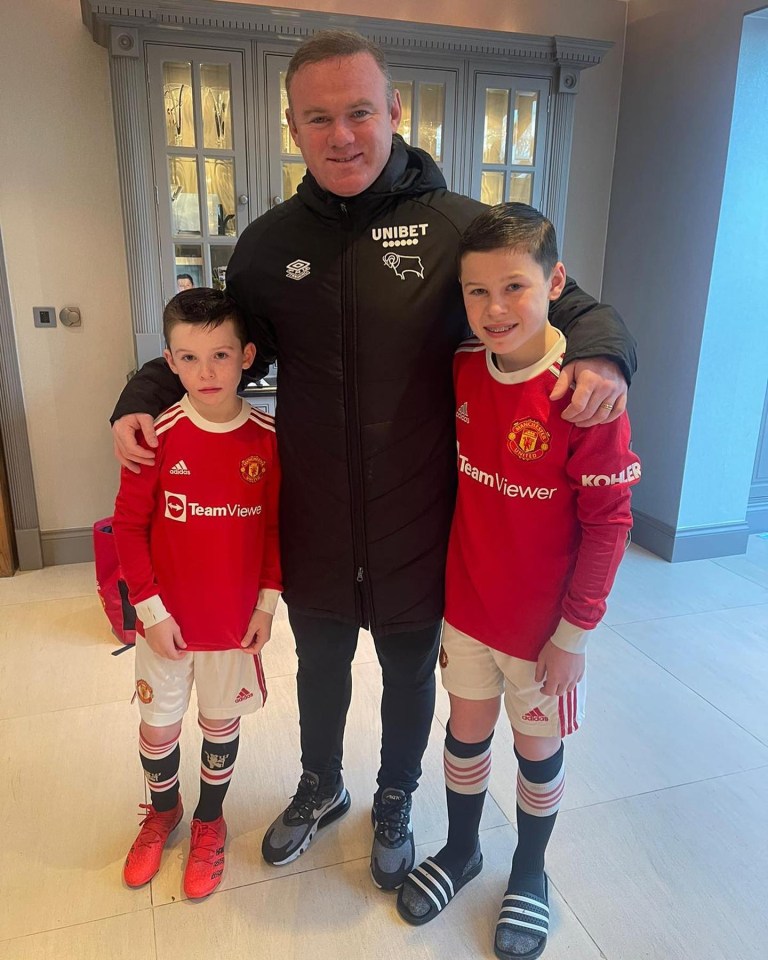 Wayne Rooney with his two sons, all dressed in soccer attire.
