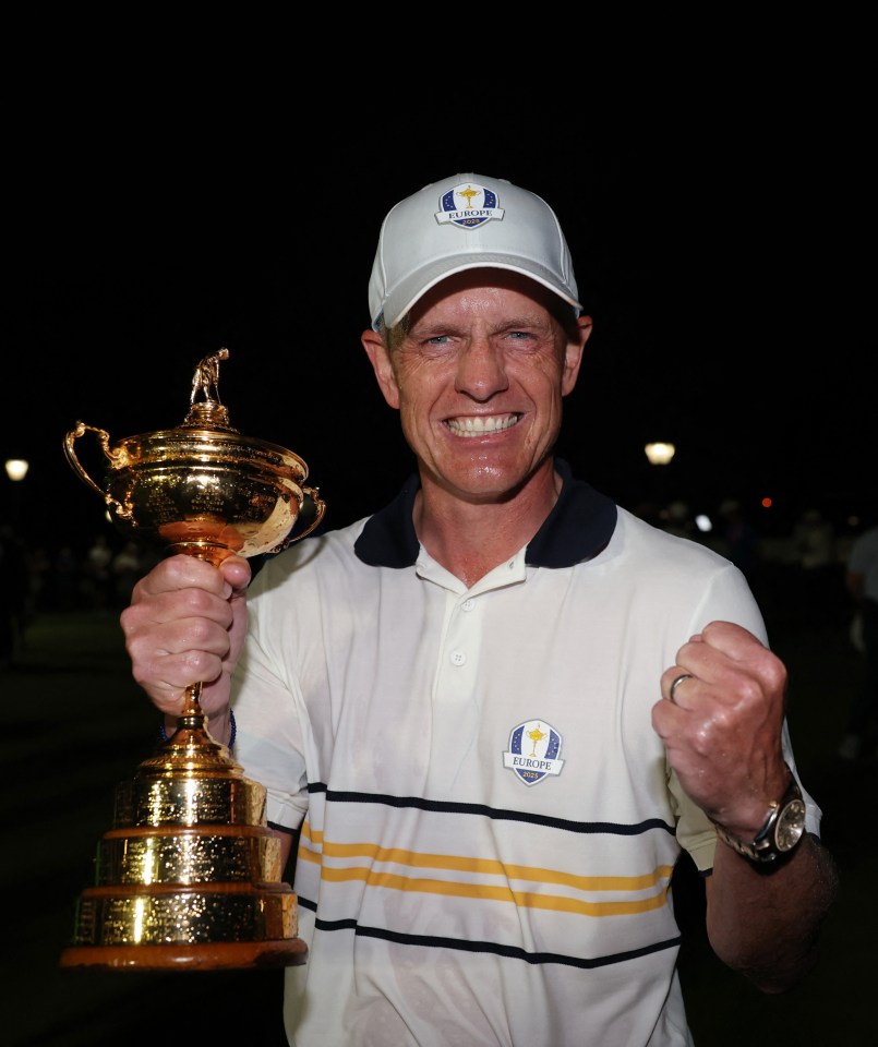 Team Europe captain Luke Donald celebrating winning the Ryder Cup, holding the trophy in one hand and making a fist with the other.