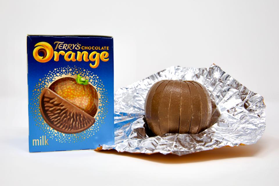 An illustration of a Terry's Chocolate Orange box with a golden orange and the text "Made with real orange oil milk" on the side.