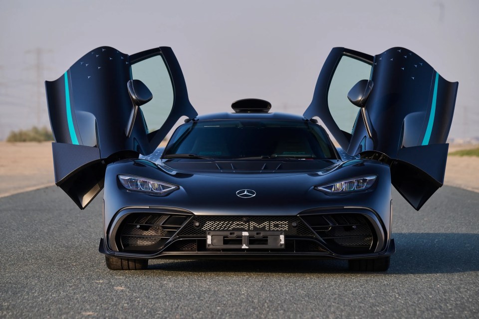 Front view of the 2024 Mercedes-Benz AMG ONE, a black hypercar with its scissor doors open.