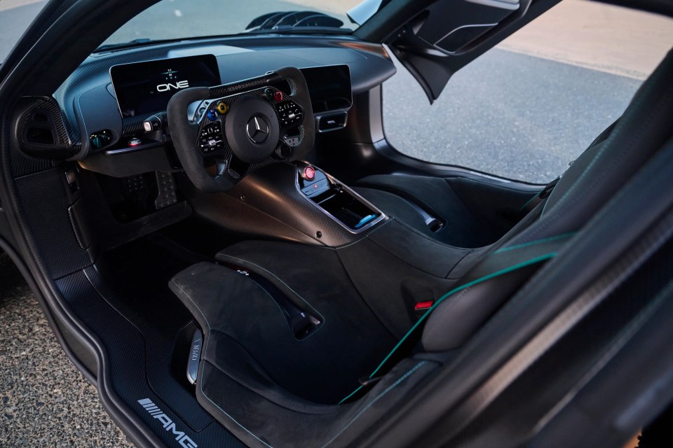 Interior of a 2024 Mercedes-Benz AMG ONE with black Alcantara and teal stitching.