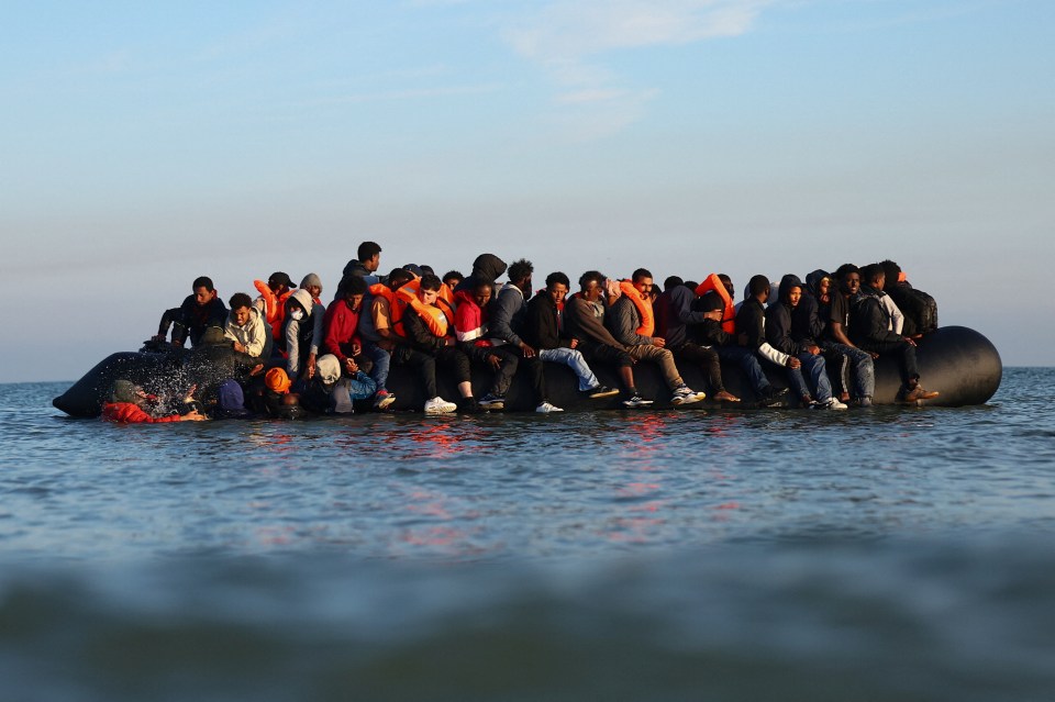 Migrants in an inflatable dinghy leaving the beach of Petit-Fort-Philippe, France to cross the English Channel.