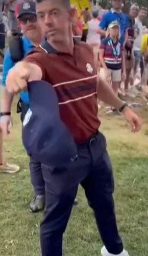 Rory McIlroy holding a golf cap.