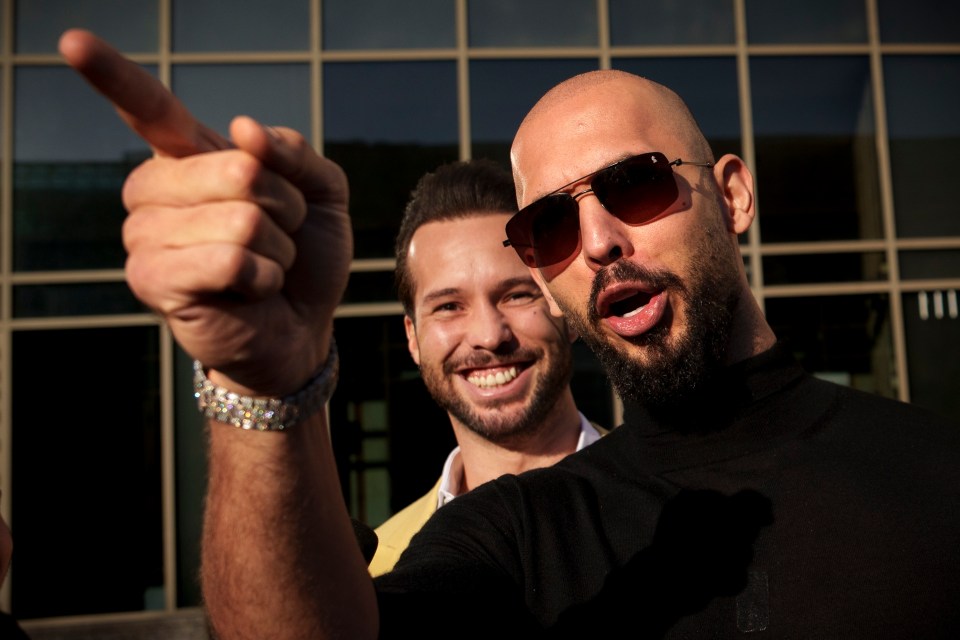 Andrew Tate gesturing next to his brother Tristan outside the Bucharest Tribunal.