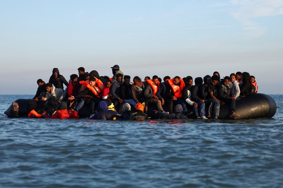 Migrants in an inflatable dinghy leaving a beach in northern France to cross the English Channel.