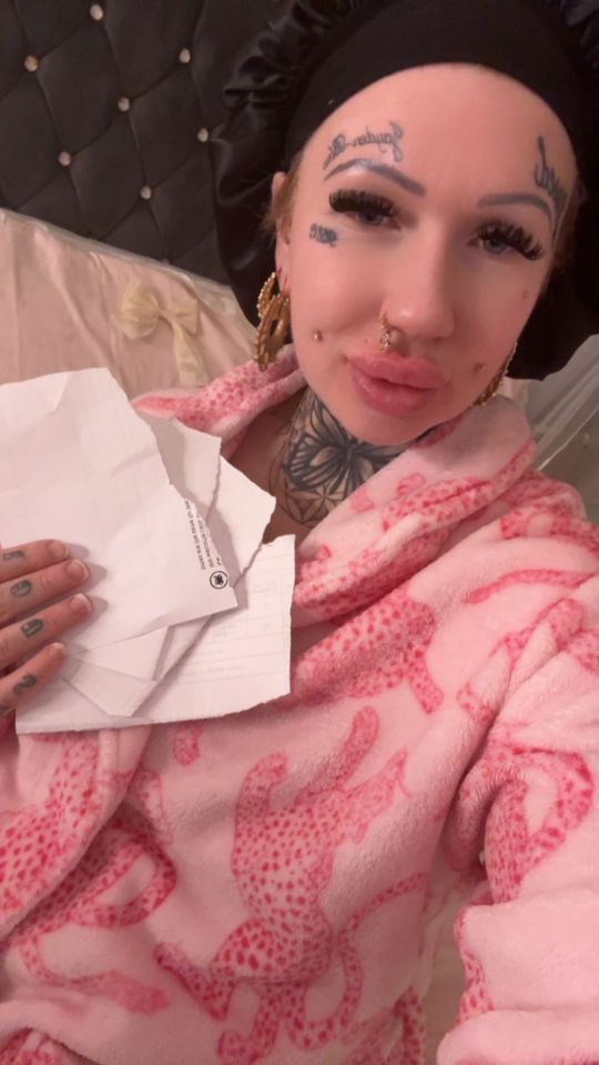 Yaz Chapman holds torn paper she eats due to pica, wearing a pink robe.