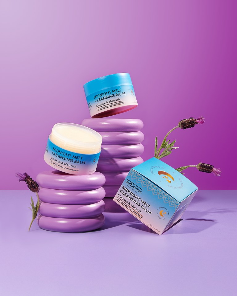 Delhicious Midnight Melt Cleansing Balm products, with two open tubs and one box, on purple background with lavender stems.