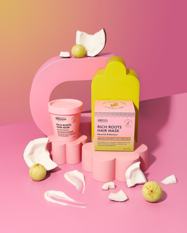 Delhicious Rich Roots Hair Mask tub and box, with coconut pieces, amla fruit, and hair mask smears.