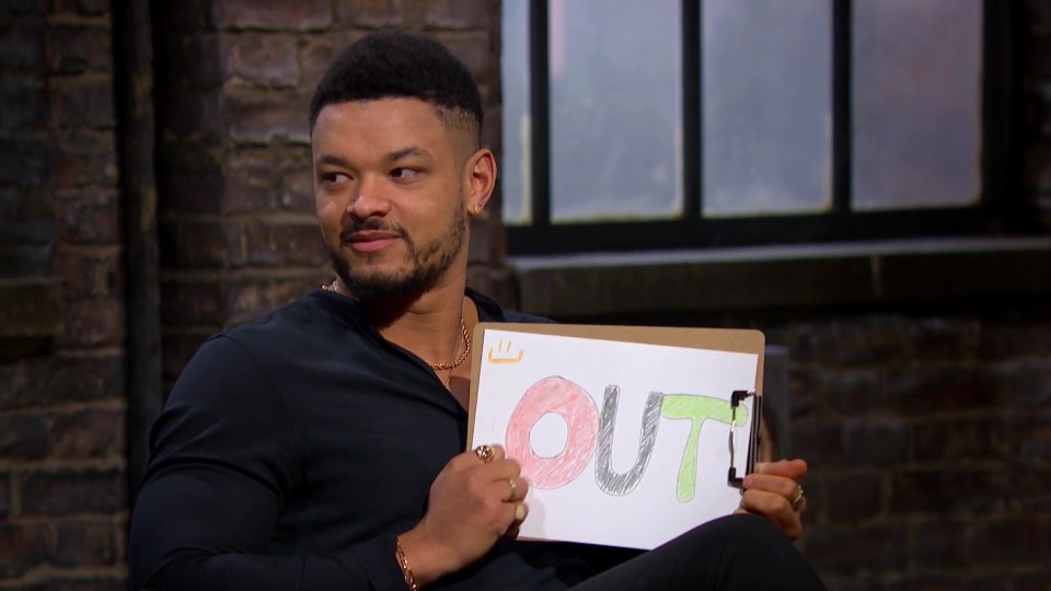 Steven Bartlett holding up a sign that says "OUT" in colorful crayon.