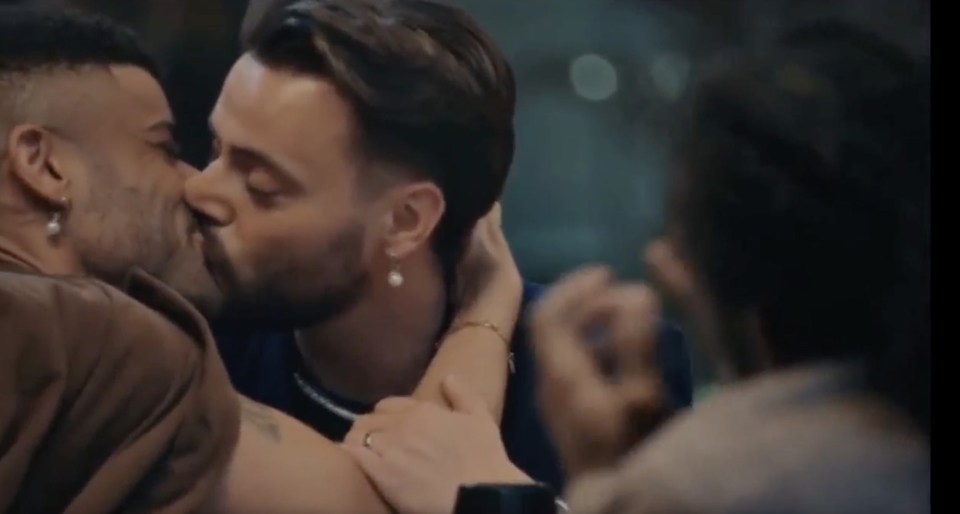 Two men kissing.