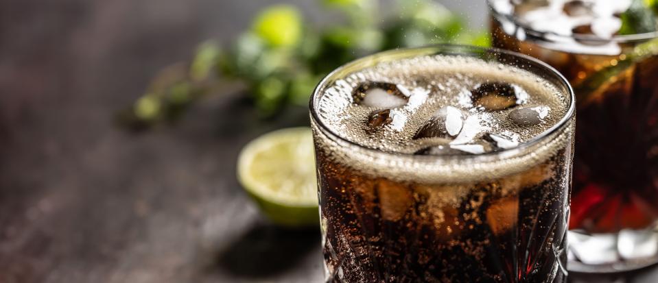 2WPDDPB Bubbling Coke drink with ice cubes on the bar counter.
