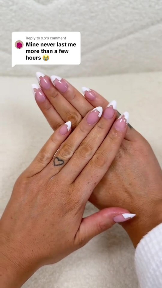 Person's hands with white and clear press-on nails, with a speech bubble showing a comment about press-on nails.