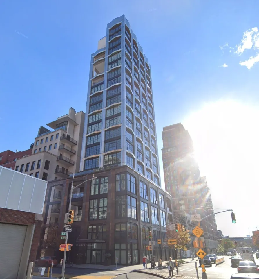 200 11th Avenue, Manhattan, a tall building with many windows, on a clear day with the sun shining brightly.