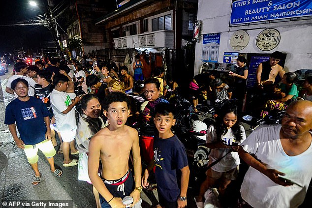 Residents gather on a street outside their homes after earthquake tremors at Mandaue in Cebu, central Philippines