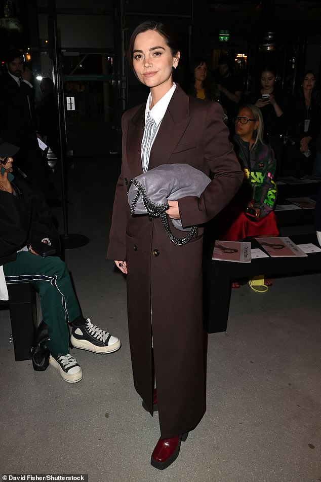 Jenna Coleman cut a chic figure in a sharp burgundy trouser suit, teamed with a pale blue and white striped shirt