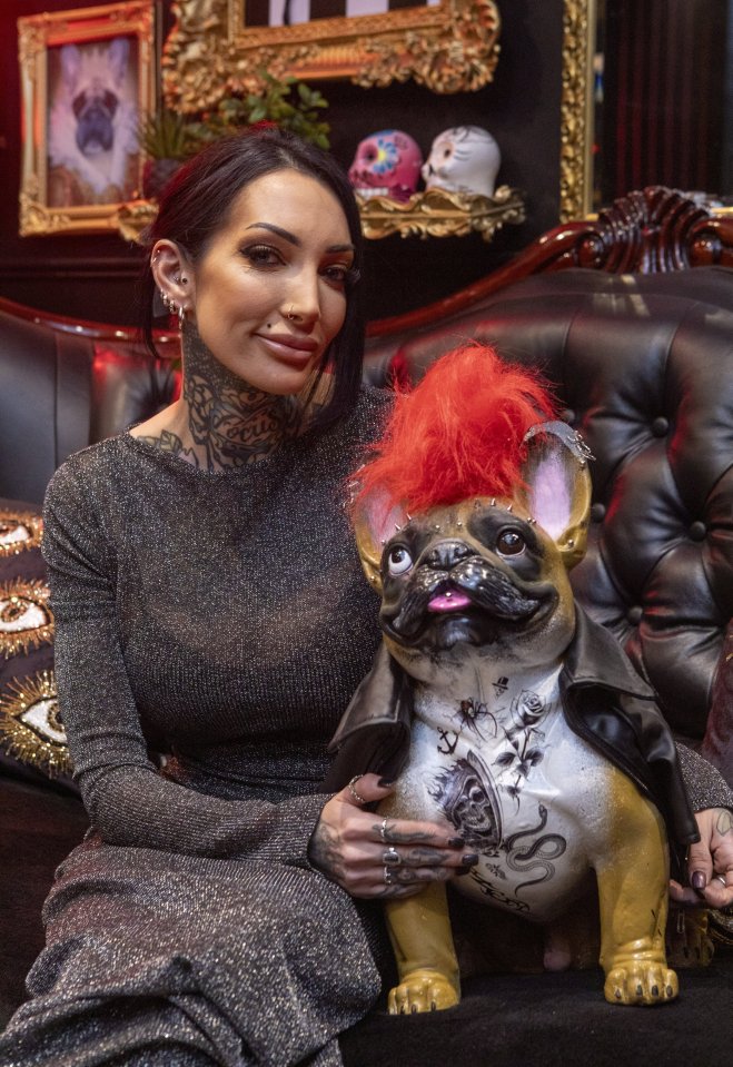 Ashleigh Anderson in her home, next to a bulldog sculpture with a red mohawk.