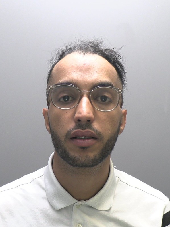 Mugshot of Adam Zawi, a man with glasses and a beard.