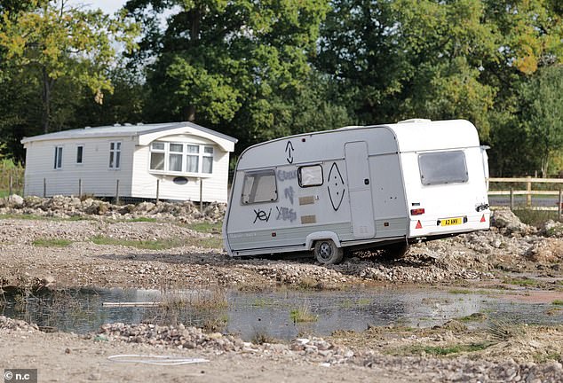 Travellers have allegedly ripped up the land, which used to be a field in part of Surrey's green belt (pictured are some of the caravans and mobile homes in Bones Lane this week)