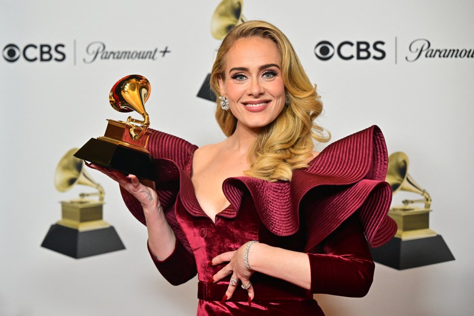 Adele poses with her Grammy Award for Best Pop Solo Performance.