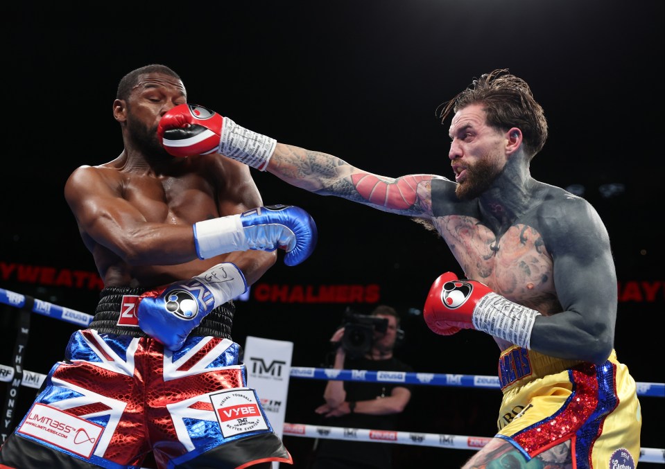 Floyd Mayweather Jr. punches Aaron Chalmers during a boxing match.