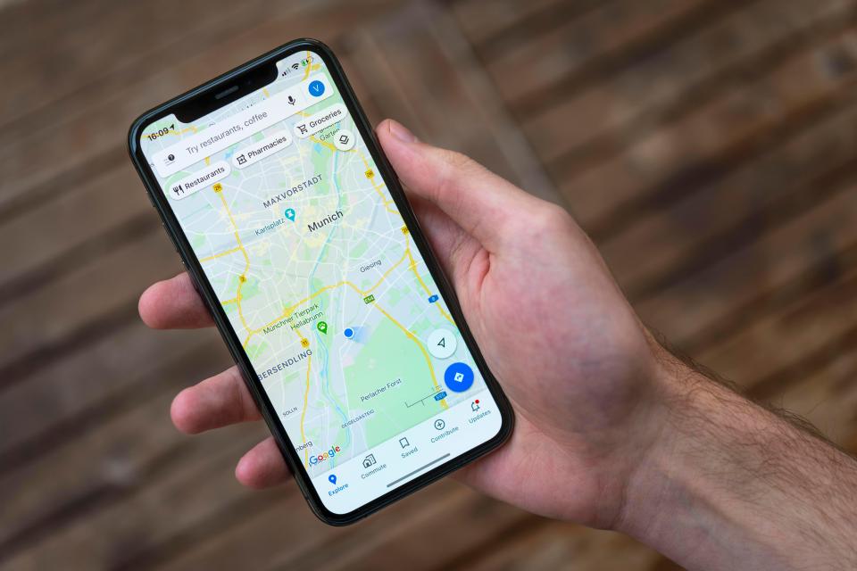 Hand holding iPhone displaying Google Maps navigation in Munich.