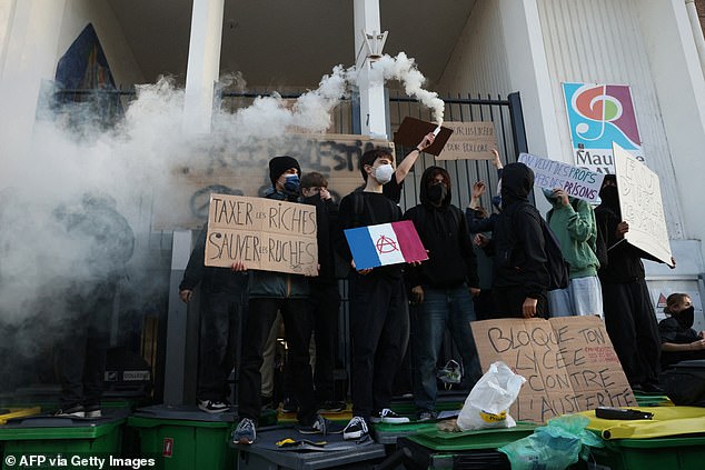 Students block the entrance to their school in Paris' 20th district, on September 18, 2025, during a day of nationwide strikes and protests called by unions over France's national budget