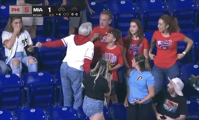 A woman Phillies fan (white jersey) was seen berating a man for beating her to a foul ball