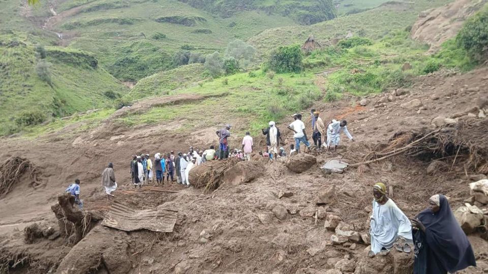 Aftermath of a landslide in western Sudan, showing people surveying the damage.