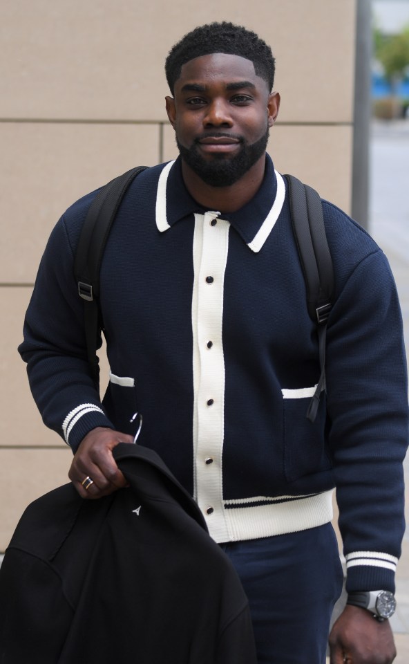Micah Richards carrying a jacket.