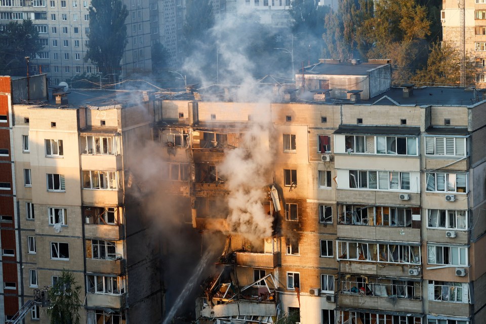 Firefighters extinguishing a fire in a damaged apartment building.