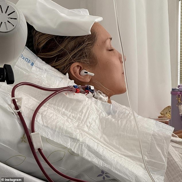 The catwalk expert had tubes by her neck as she had ear buds in