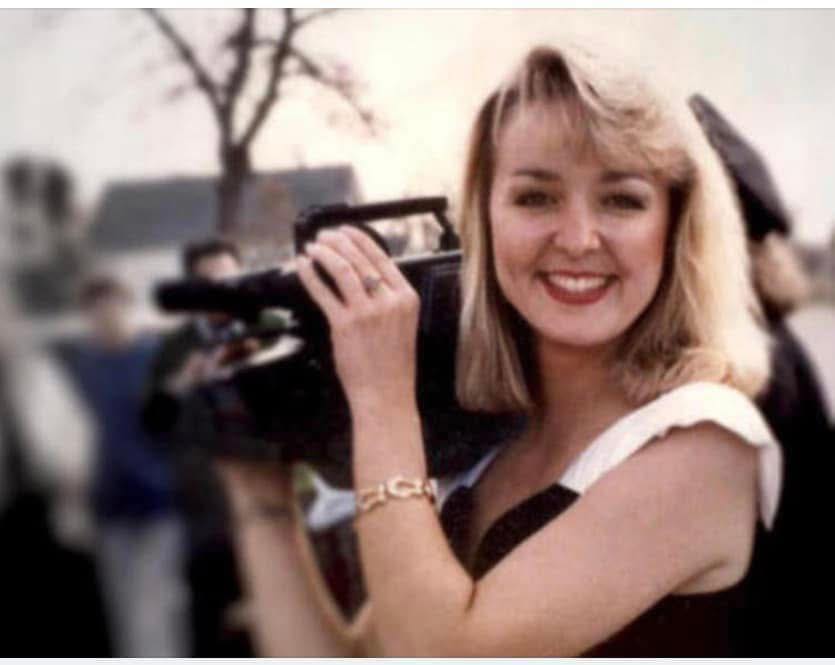 Jodi Huisentruit smiling while holding a camera.