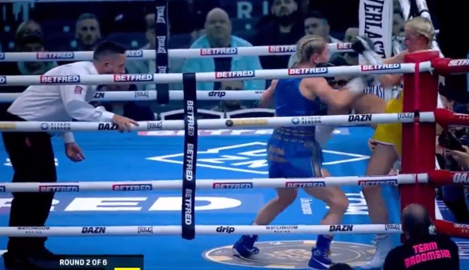Two female boxers fighting in a boxing ring.