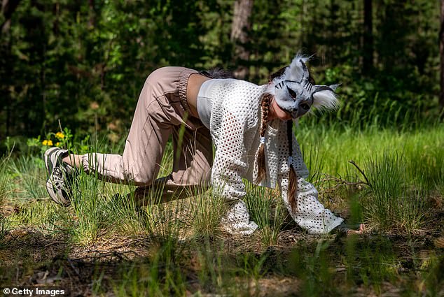 Quadrobics is a new fitness trend of imitating animal movements. A file photo above shows a teenage girl with cat mask and gloves doing Quadrobics
