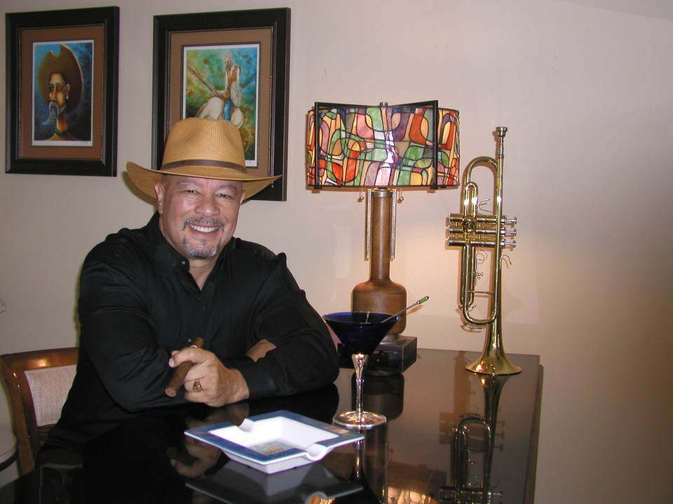 Martin Suarez in a straw hat holding a cigar.