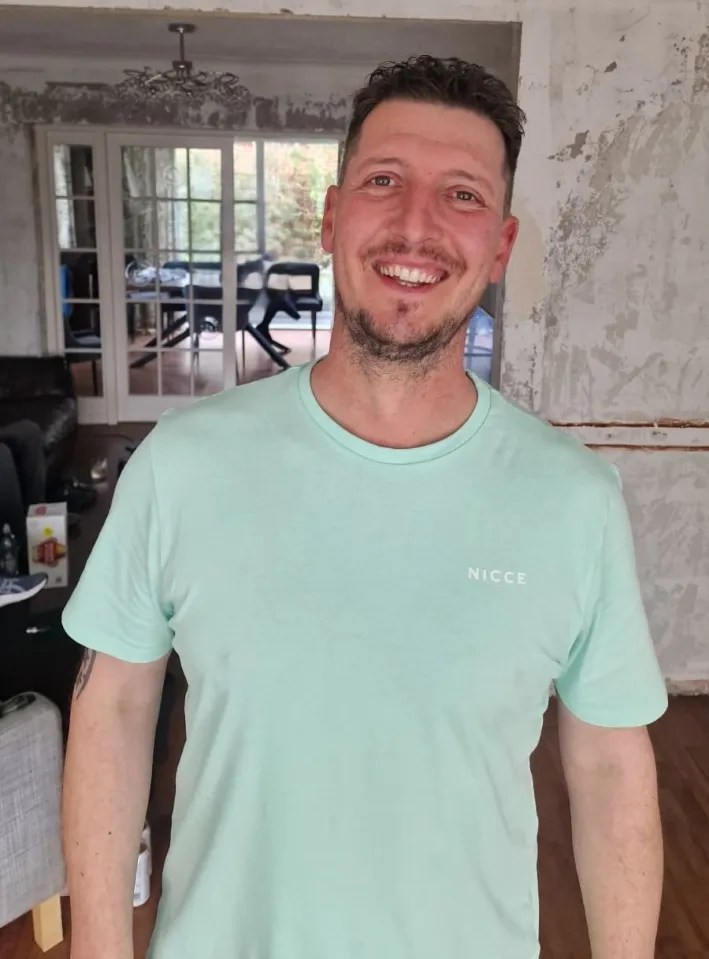 Man in mint green shirt smiling.