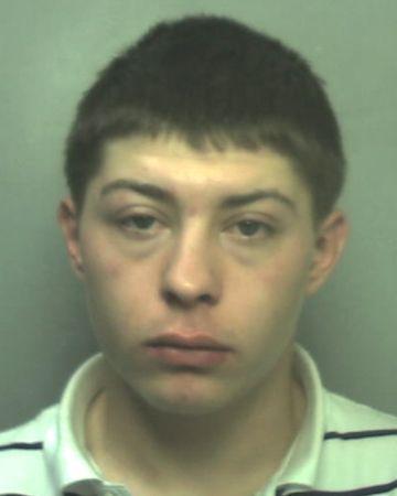 Mugshot of a young man with short dark hair, wearing a white polo shirt.