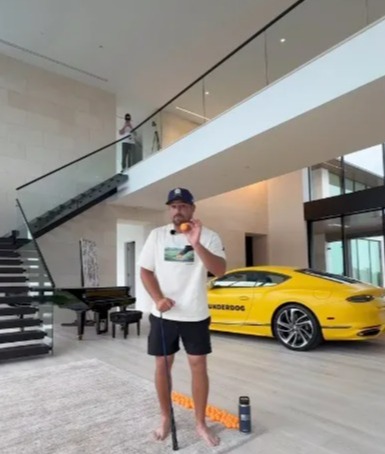 Man practicing putting in a luxurious home.