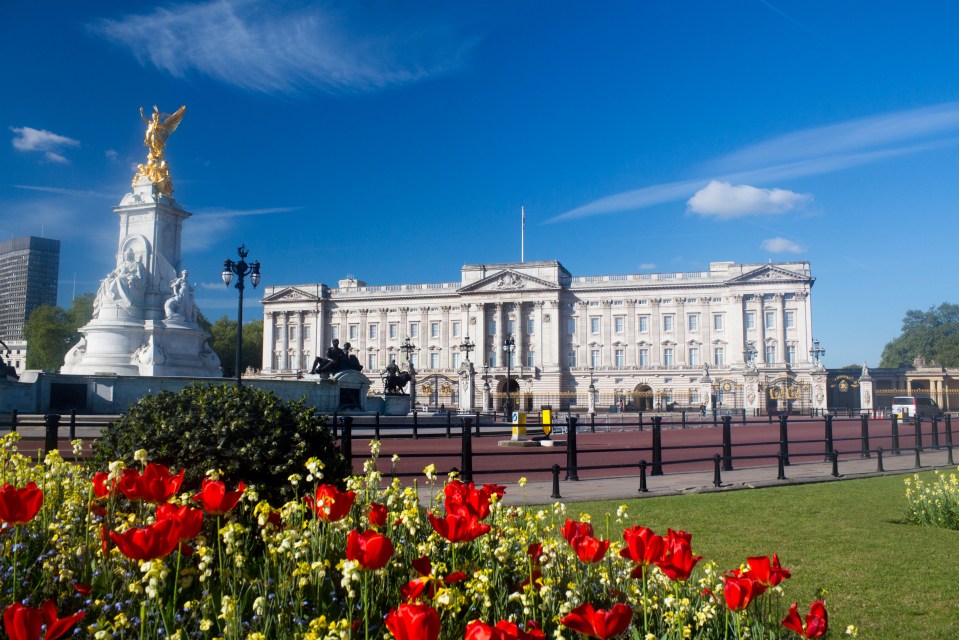 E0EJ25 Buckingham Palace in spring with tulips and flowers in foreground Victoria Memorial to right of frame London England UK