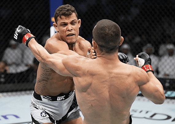 Two MMA fighters exchanging blows in the octagon.