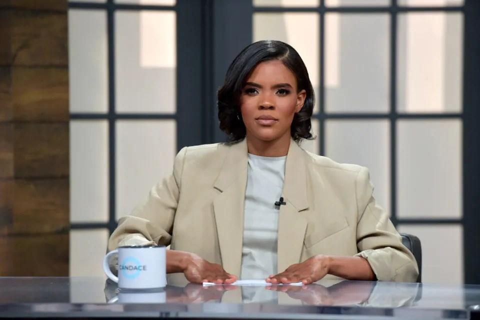 Candace Owens sitting at a desk with a mug.