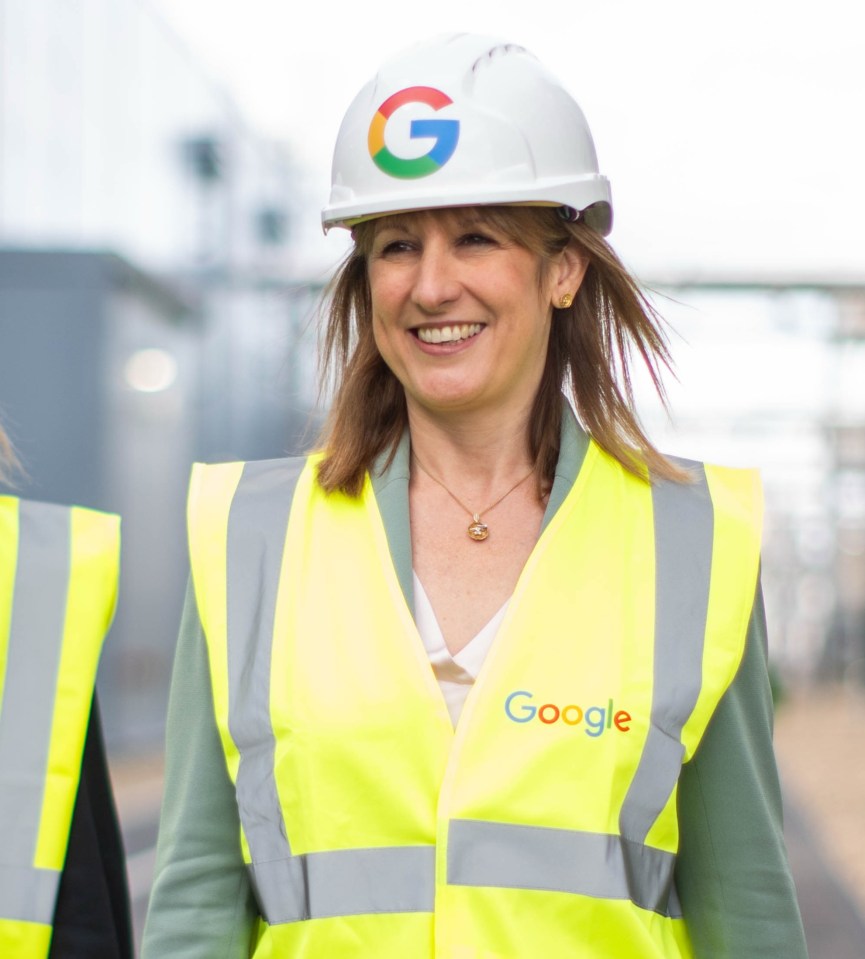 Ruth Porat, Liz Kendall, and Rachel Reeves, wearing Google branded hard hats and safety vests, at the opening of Google's new data centre.